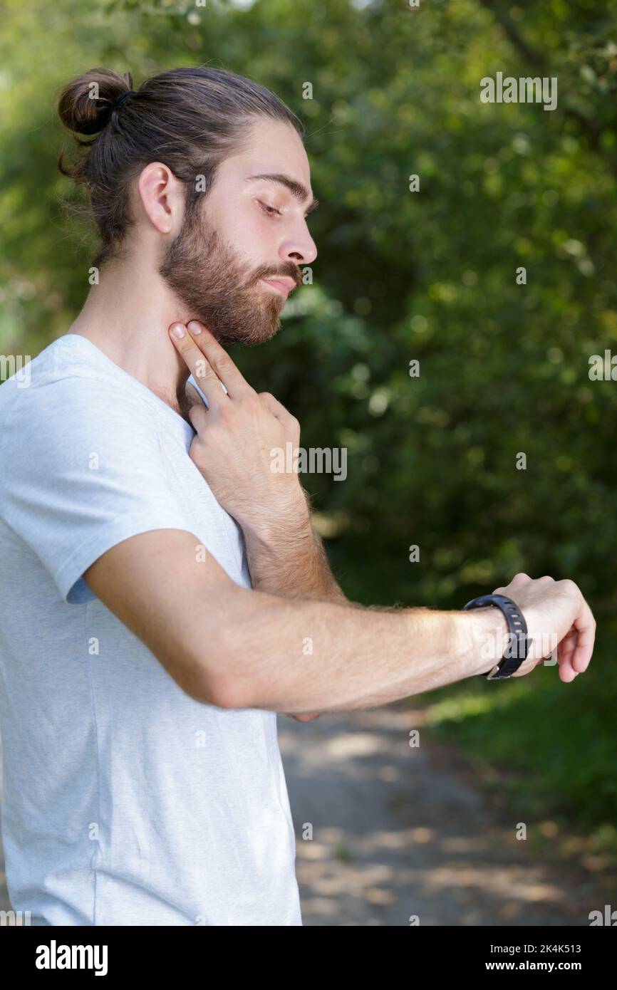 runner checking his heart rate pulse Stock Photo