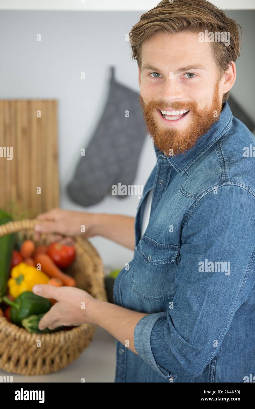 a friendly man with a huge basket of vegetables Stock Photo