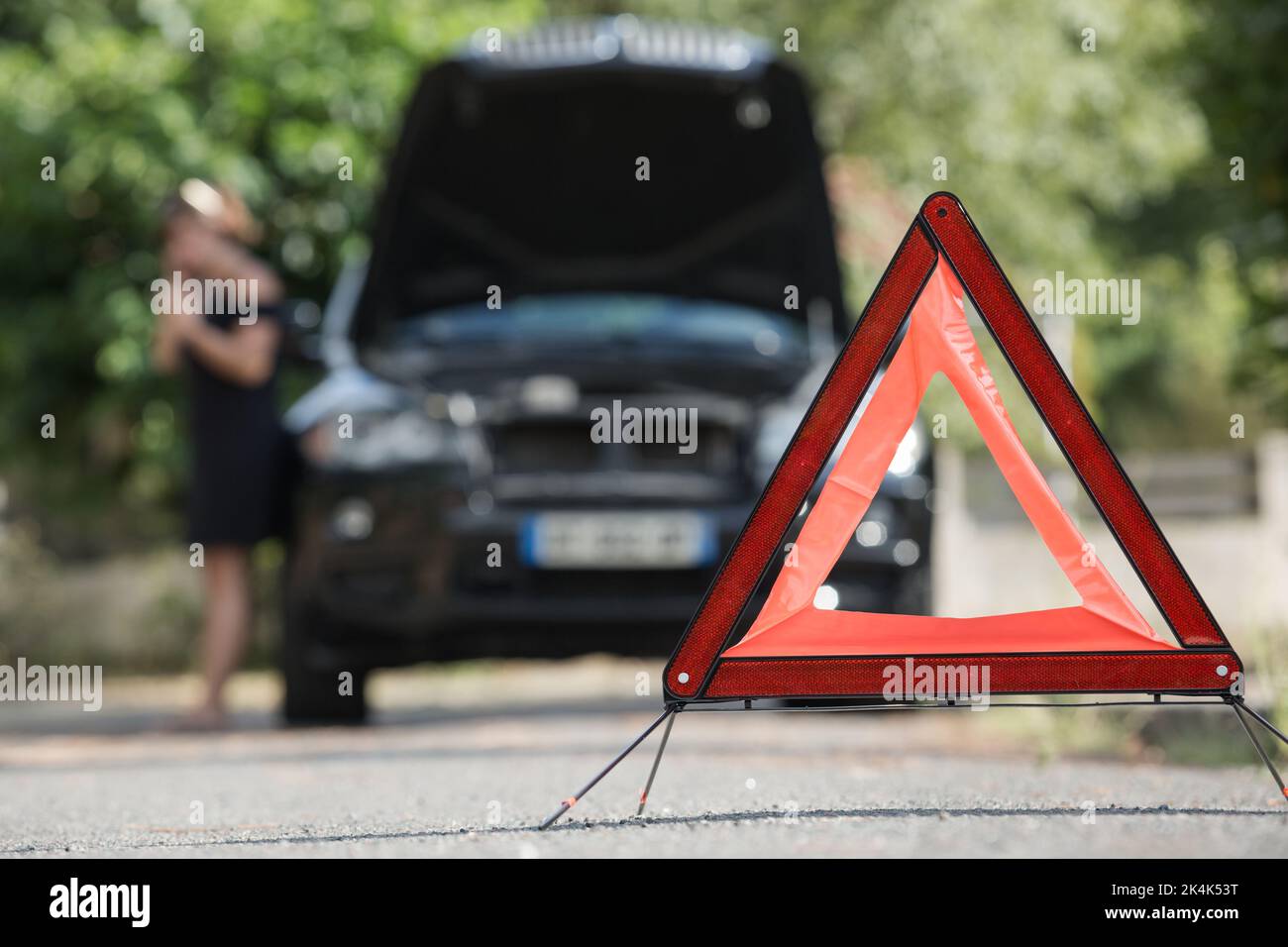 red warning triangle with a broken down car Stock Photo - Alamy