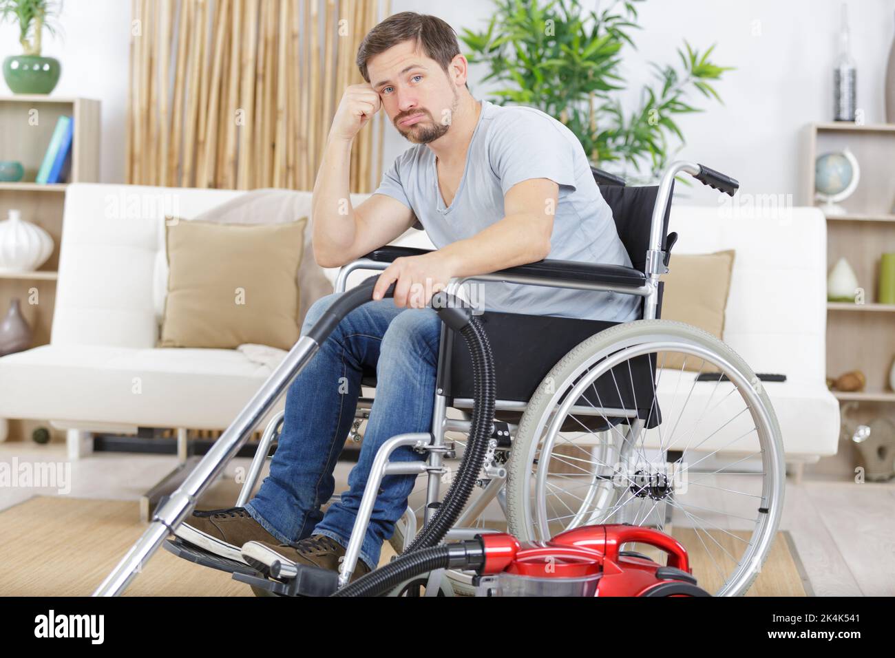 borde disabled man in wheelchair uses a vacuum cleaner Stock Photo Alamy