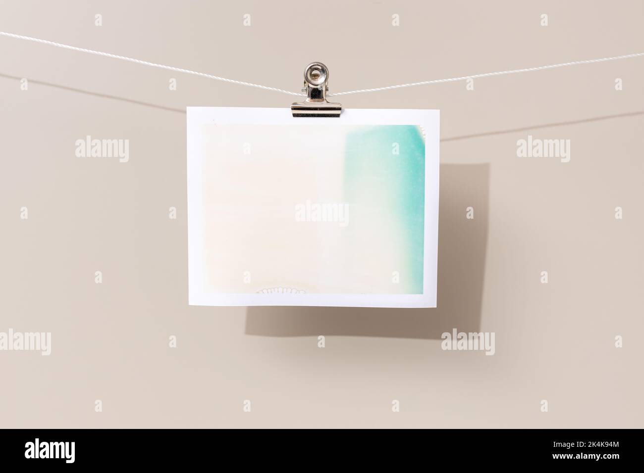instant photo frame with green and beige patches hanging on a rope Stock Photo