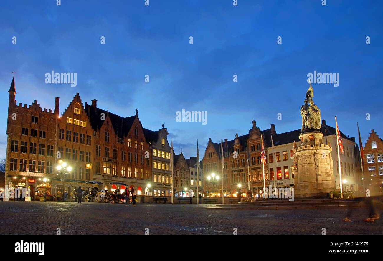 Brugge or Bruges, West Flanders, Belgium : The Market Square in Brugge at night with traditional old buildings and statue. Stock Photo