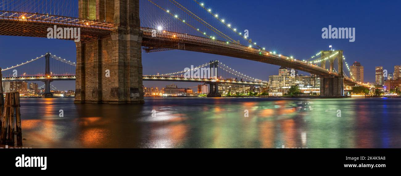 Evening panoramic view of the Brooklyn Bridge and Manhattan Bridge with East River. Dumbo, New York City Stock Photo