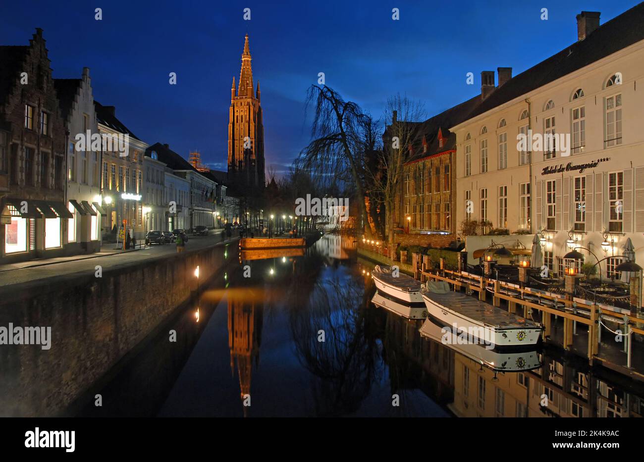 Brugge or Bruges, West Flanders, Belgium : The Dijver Canal in Brugge at night with the Onze Lieve Vrouwekerk or Church of Our Lady. Stock Photo