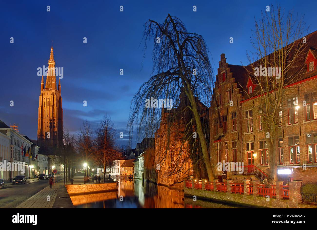 Brugge or Bruges, West Flanders, Belgium : The Dijver Canal in Brugge at night with the Onze Lieve Vrouwekerk or Church of Our Lady. Stock Photo