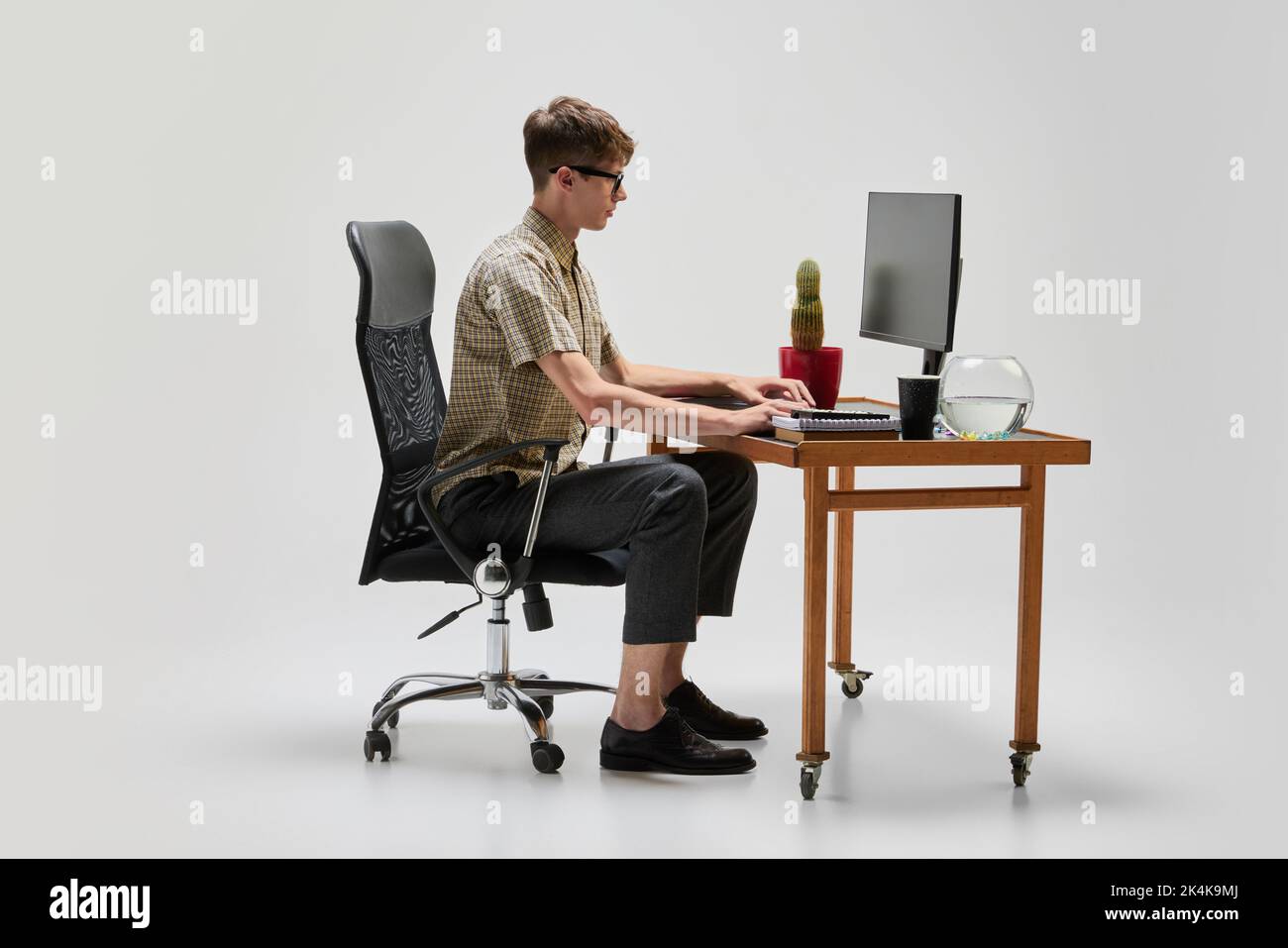Young programmer. Portrait of smart and serious student sitting at computer desk and studying. Studying, education, youth, remote workplace concept Stock Photo