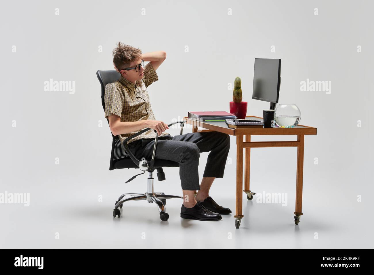 Portrait of smart and serious student sitting at computer desk and studying. Business, studying, education, youth, remote workplace concept Stock Photo