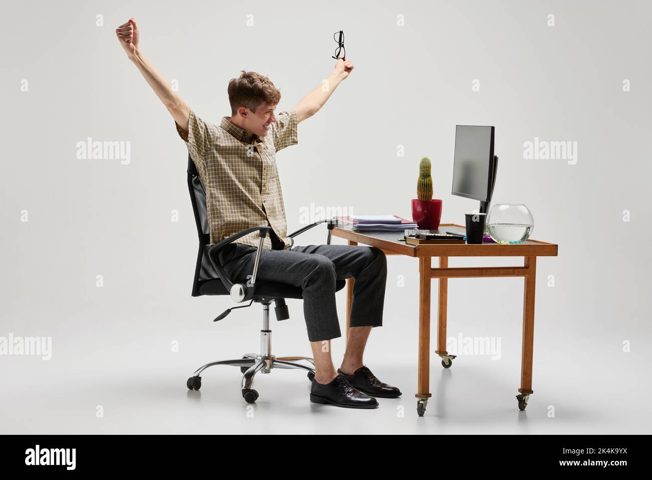 Happy and cheerful student sitting at computer desk and studying. Business, career, home education, youth, remote workplace concept Stock Photo