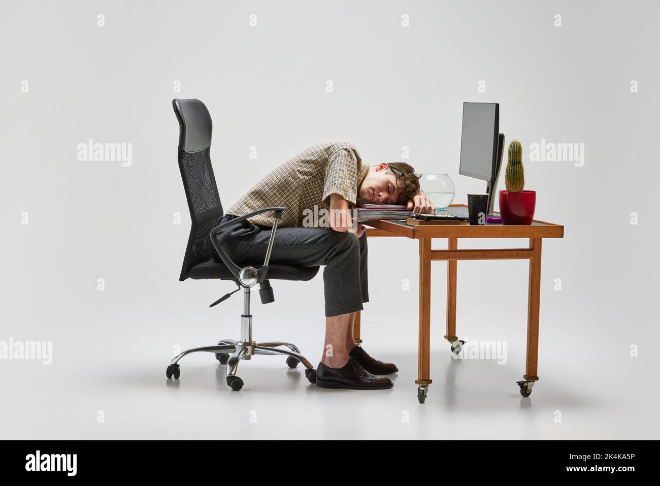Napping. Young man, student sitting at computer desk and sleeping after hard day. Business, studying, education, youth, remote workplace concept Stock Photo