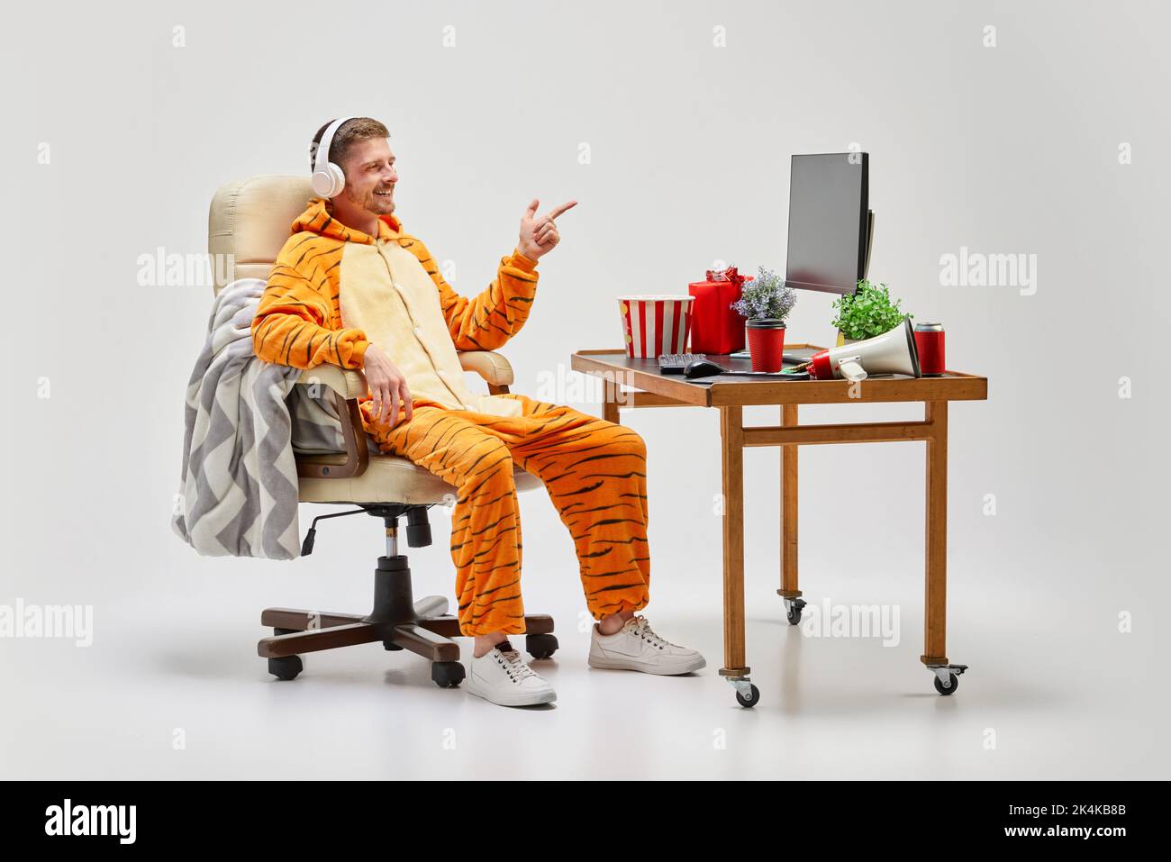 Young man in amazing costume sitting at computer desk at home. Art, ideas, creativity, working and holidays concept Stock Photo