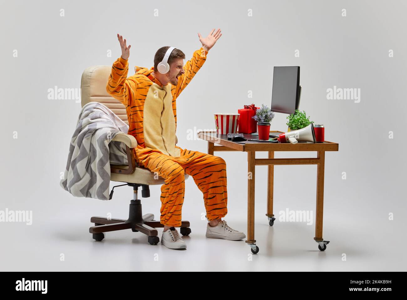 Angry man in amazing costume sitting at computer desk at home. Art, ideas, creativity, working and holidays concept Stock Photo