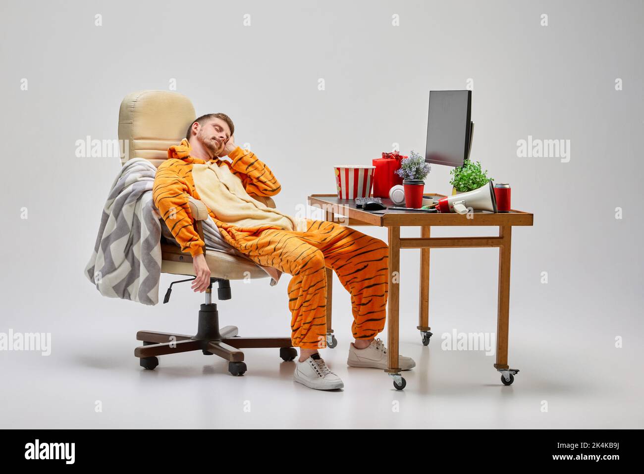 Napping. Young man in amazing costume sitting at computer desk and sleeping. Art, ideas, creativity, working and holidays concept Stock Photo