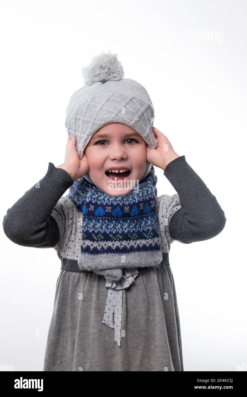 Portrait of a little girl in a hat and scarf on a white background. Stock Photo