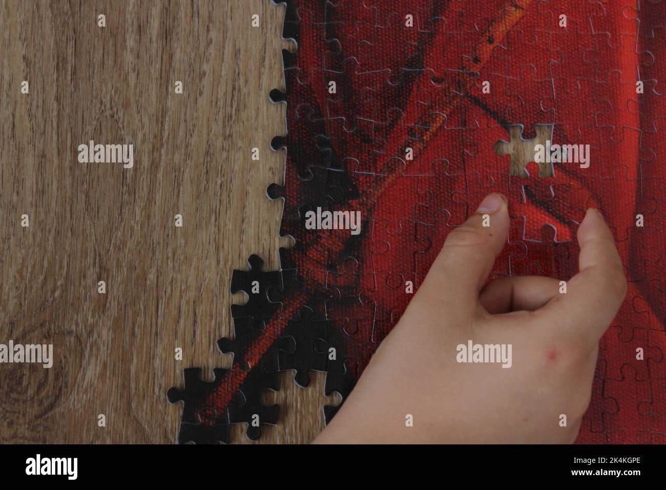 A boy holding red puzzle piece to put it place. Jigsaw concept idea