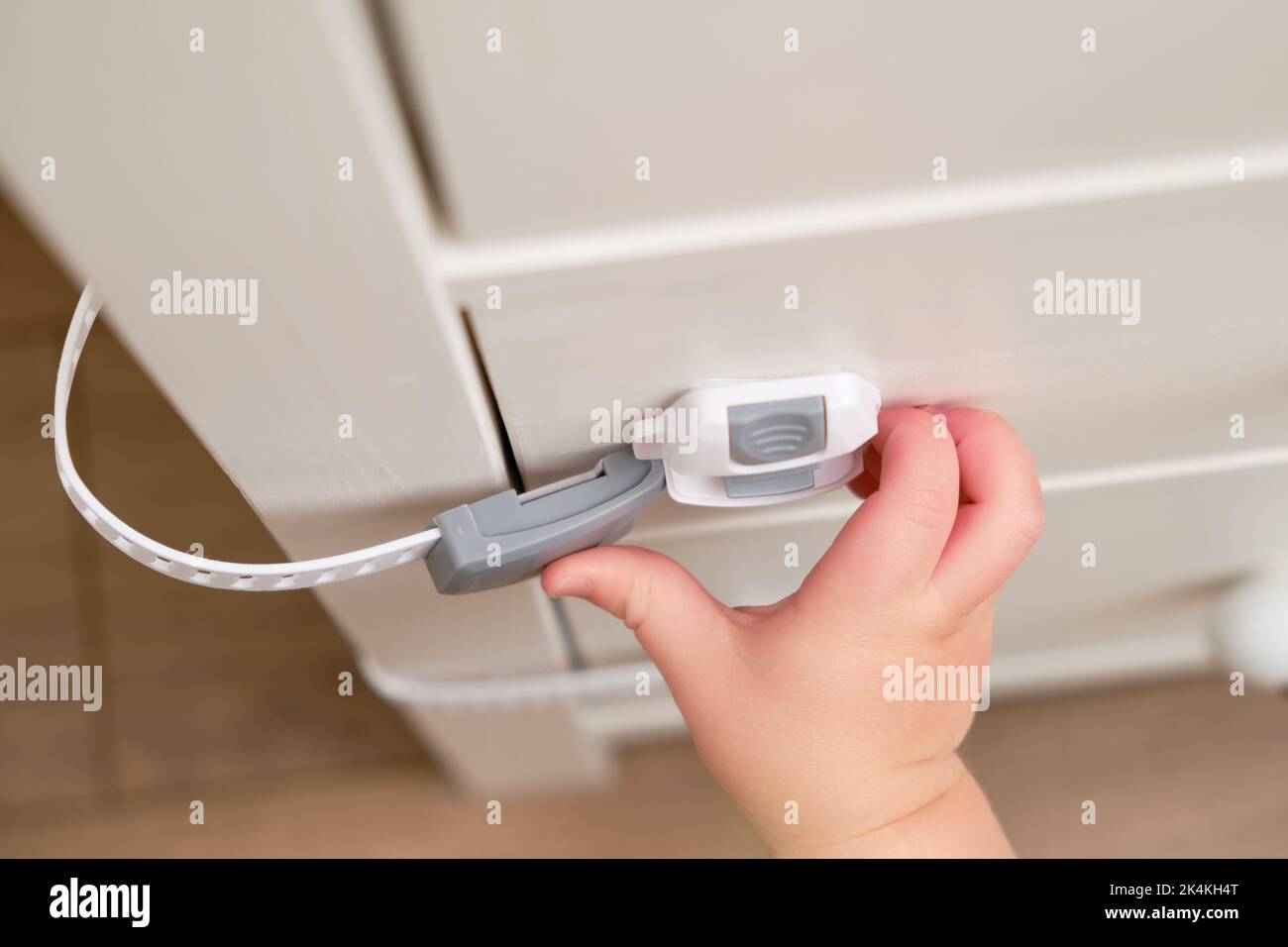 Baby opens the child lock on the closed drawer of the Toddler