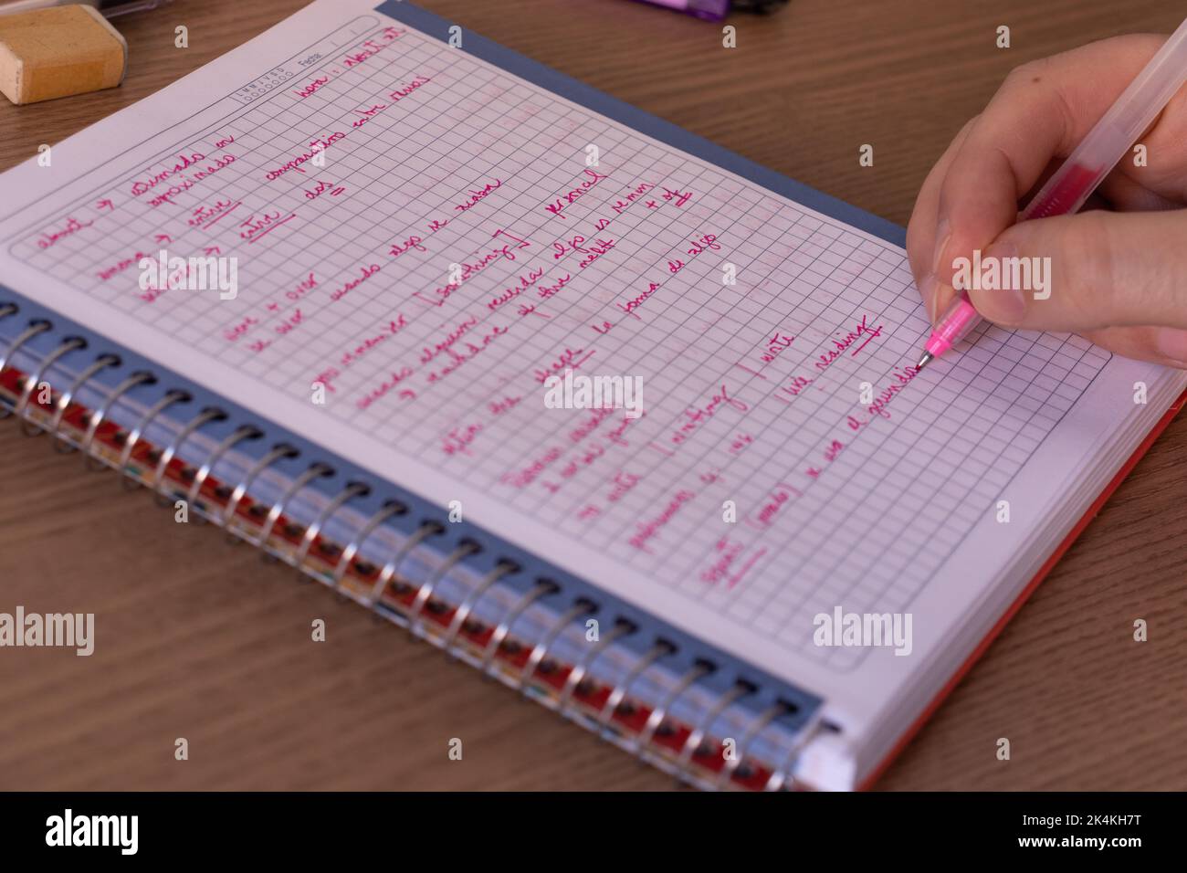 Man doing English homework on a notebook writing with a pen Stock Photo