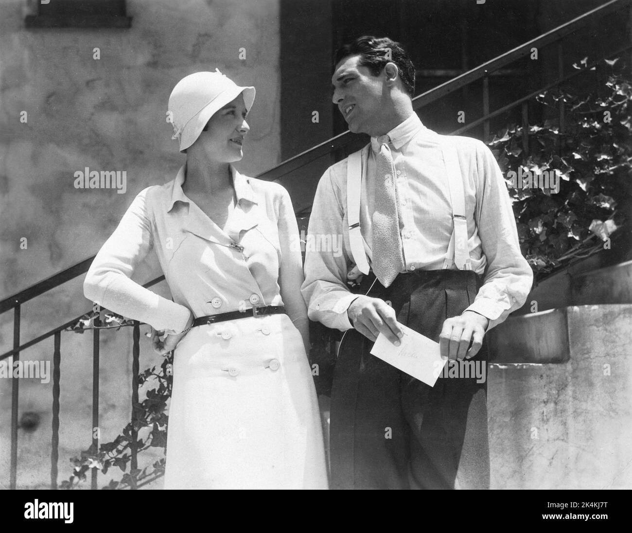 CARY GRANT (holding hand delivered letter addressed to his real name Archie) with visiting Picture Show British film magazine journalist KATHLYN HAYDEN on the Paramount Studios Lot in Hollywood in early 1933 Stock Photo