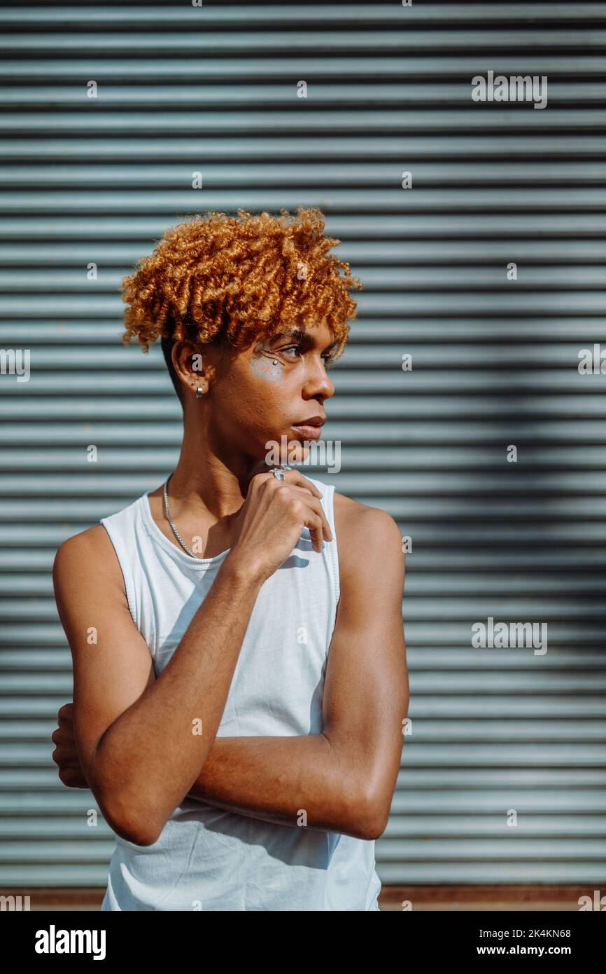 Side view of the confident teenager with creative makeup posing outdoors Stock Photo