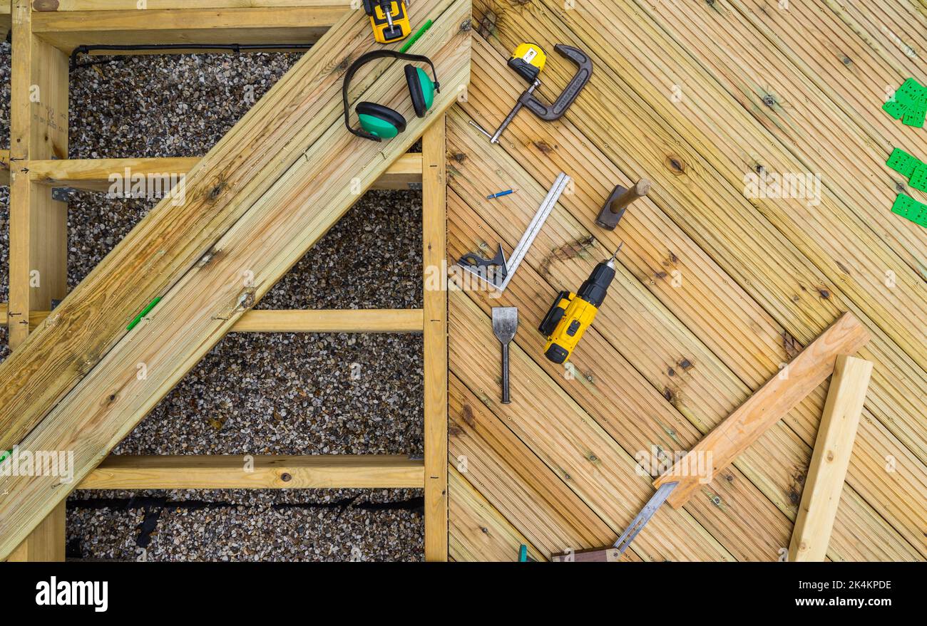 Deck under construction, showing decking joists, planks and deck tools Stock Photo