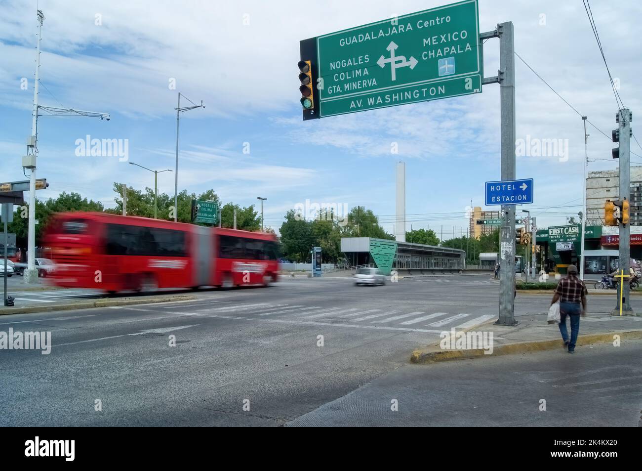 two people crossing the street with a yellow cross, in the background the city Stock Photo