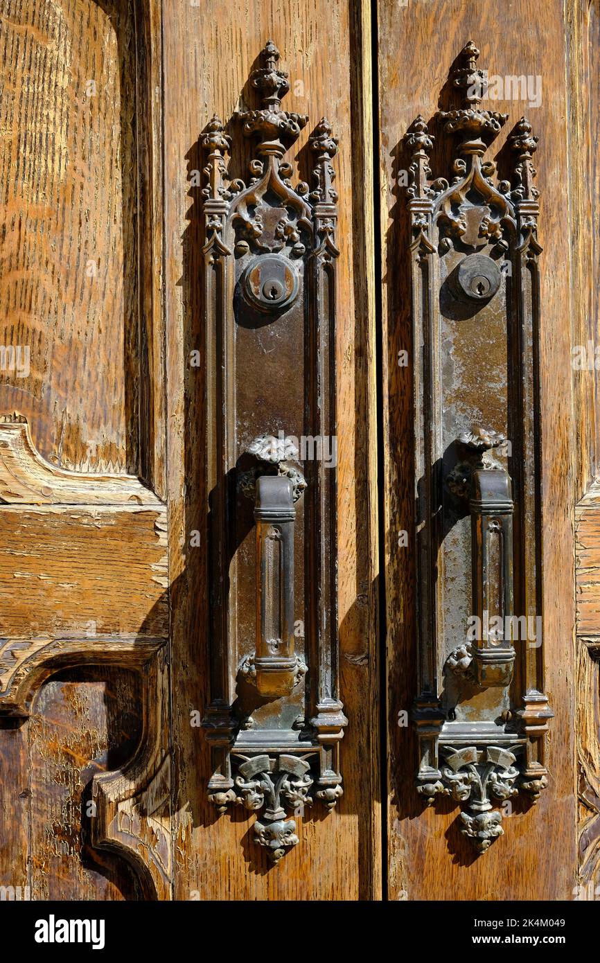 Detail of ancient antique door handles on old worn wooden doors Stock Photo