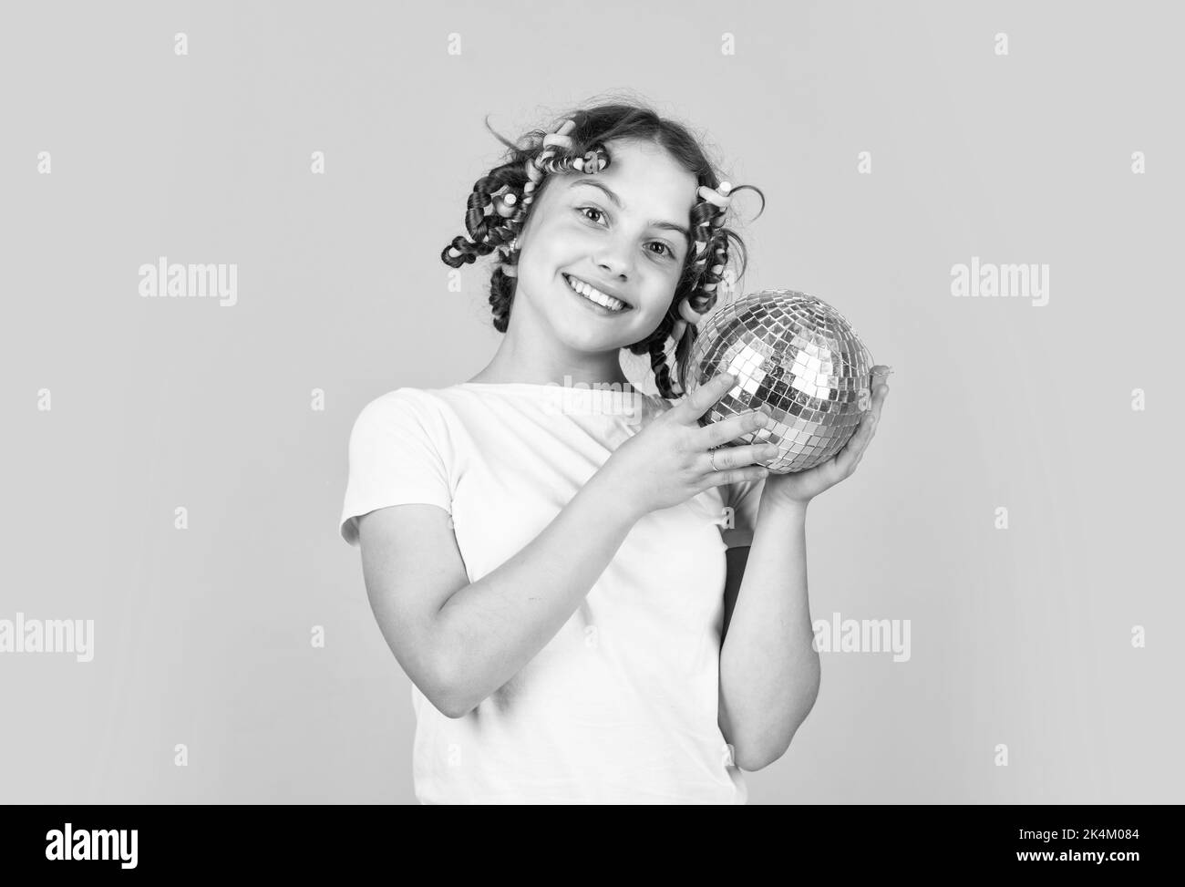 Retro party. Cheerful girl with disco ball. Fashion kid posing with