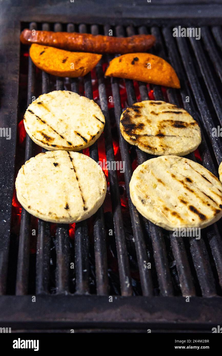 https://c8.alamy.com/comp/2K4M2BR/colombian-arepas-empanadas-and-chorizo-on-a-grill-colombian-traditional-food-2K4M2BR.jpg