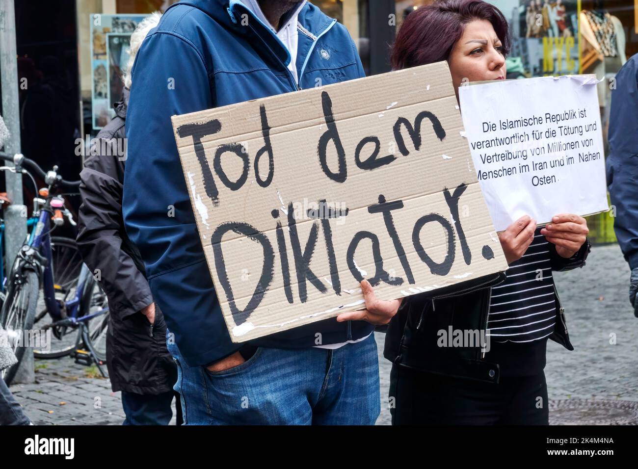 Braunschweig, Germany, October 1, 2022: Demonstrator against the government of Iran holds up a placard wishing for the dictator's death Stock Photo