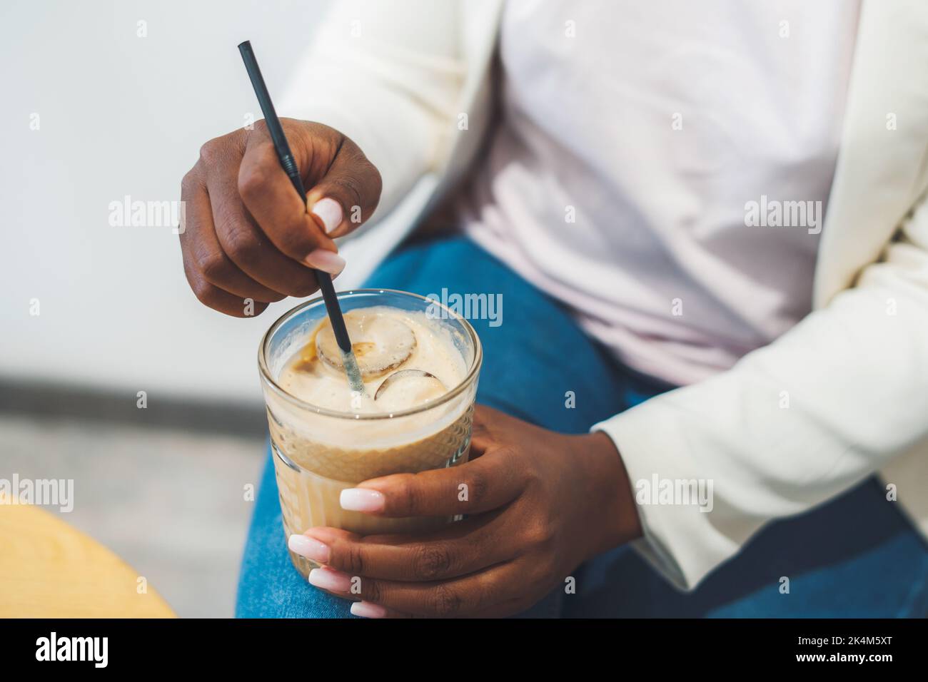 African-american woman's hands holding cold coffee drink with ice ...