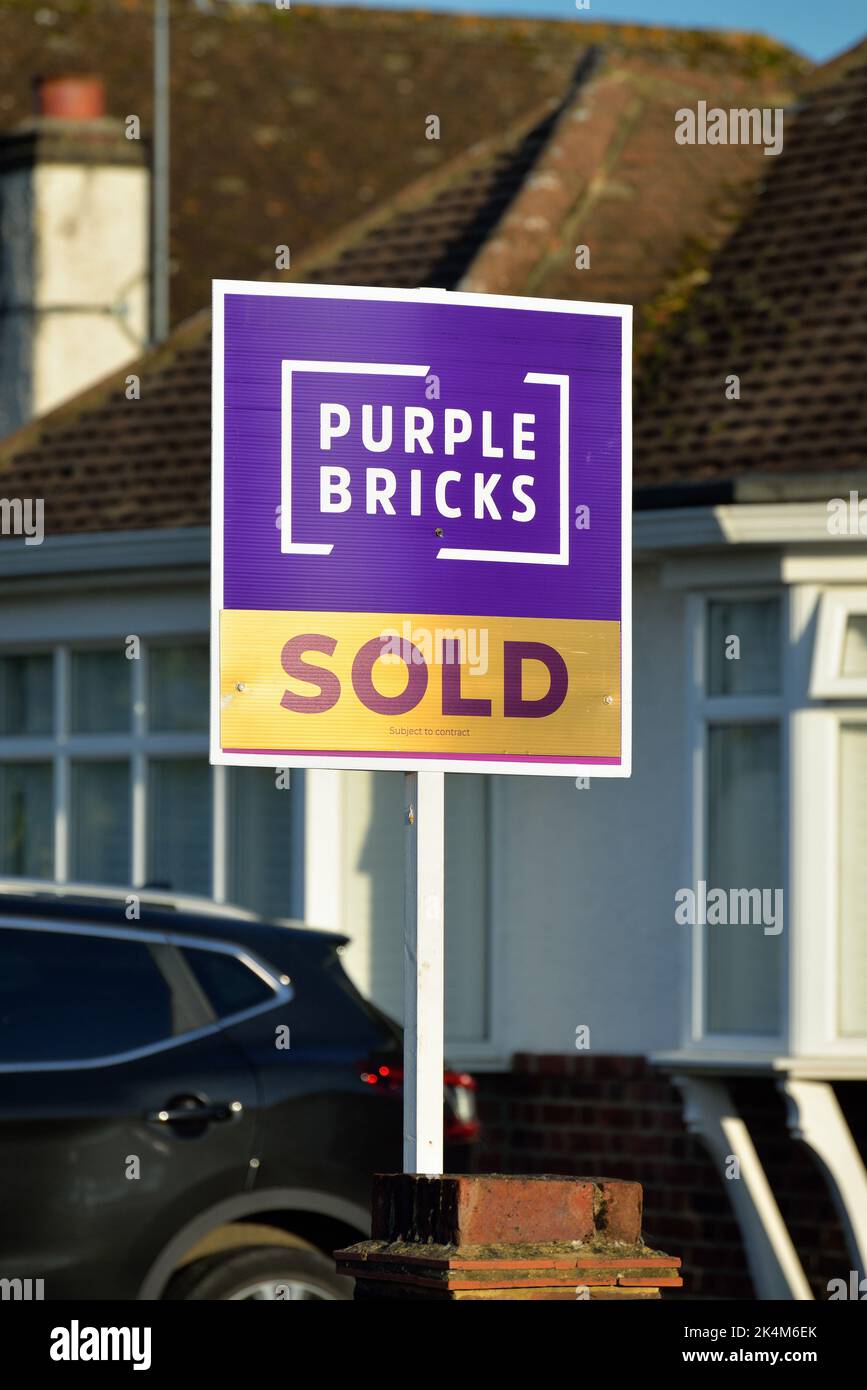 A 'Purple Bricks' online estate agents 'Sold' sign outside a suburban