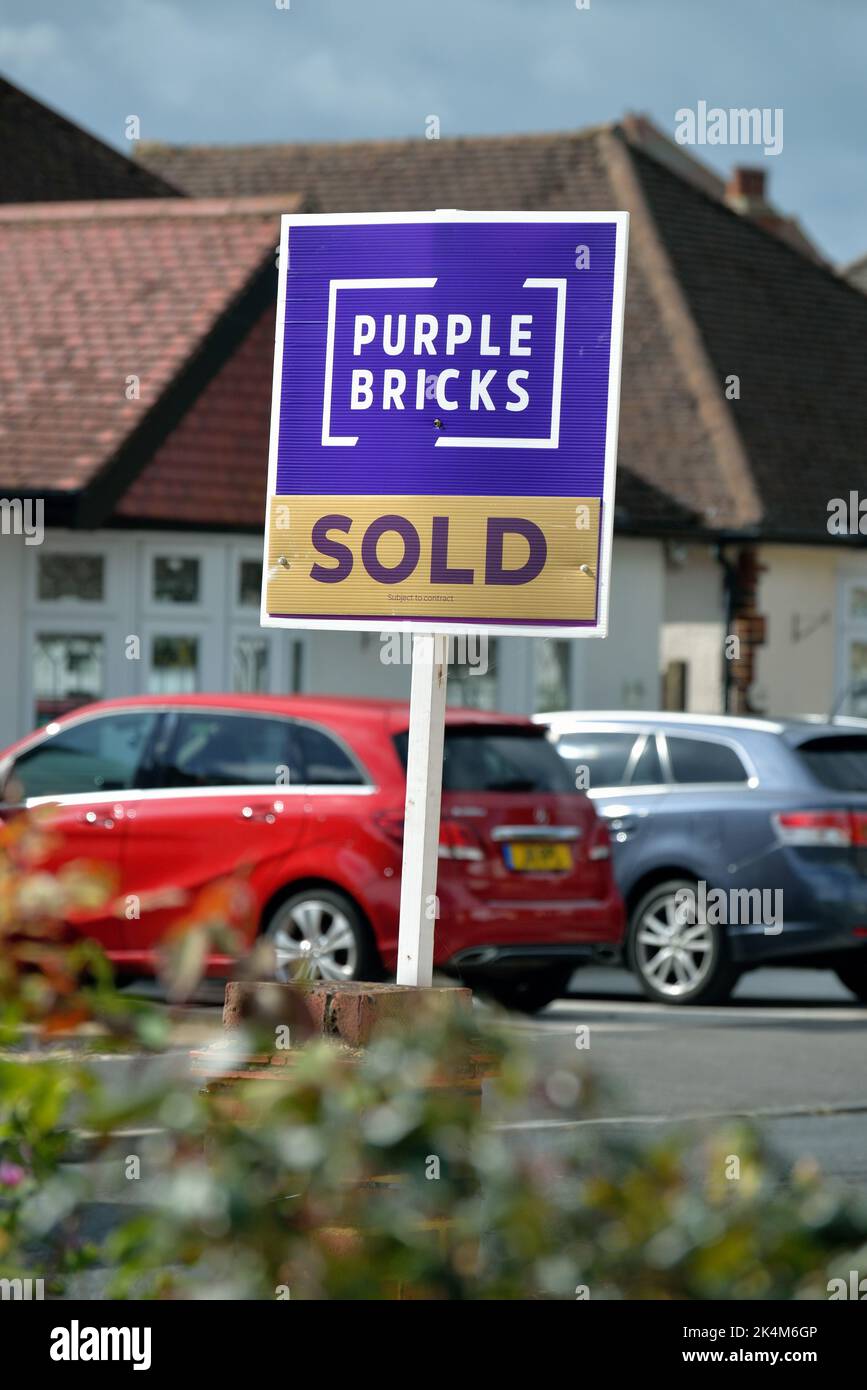 A 'Purple Bricks' online estate agents 'Sold' sign outside a suburban