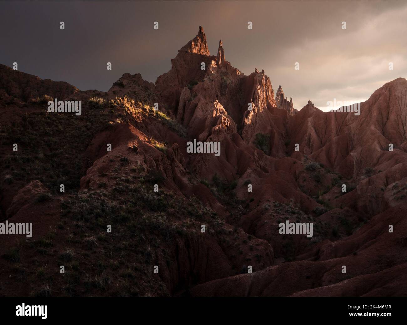 https://c8.alamy.com/comp/2K4M6MR/sharp-rock-formations-and-dramatic-sunset-at-colourful-skazka-fairytale-canyon-in-issyk-kul-region-kyrgyzstan-2K4M6MR.jpg