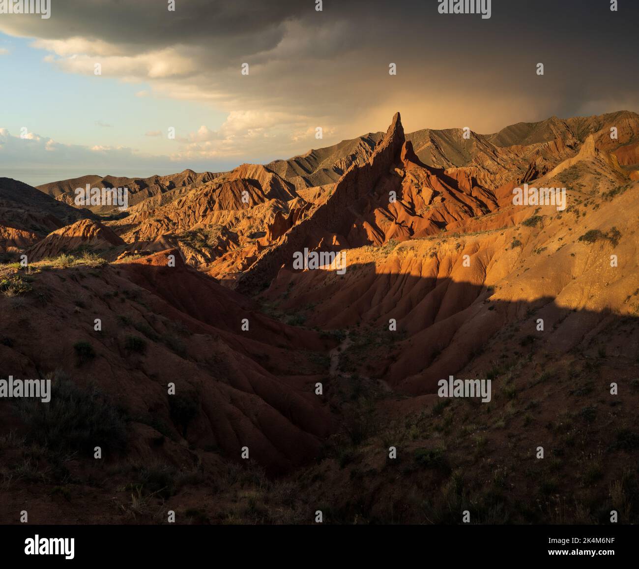 Sharp rock formations and dramatic sunset at colourful Skazka Fairytale Canyon in Issyk-Kul region, Kyrgyzstan Stock Photo