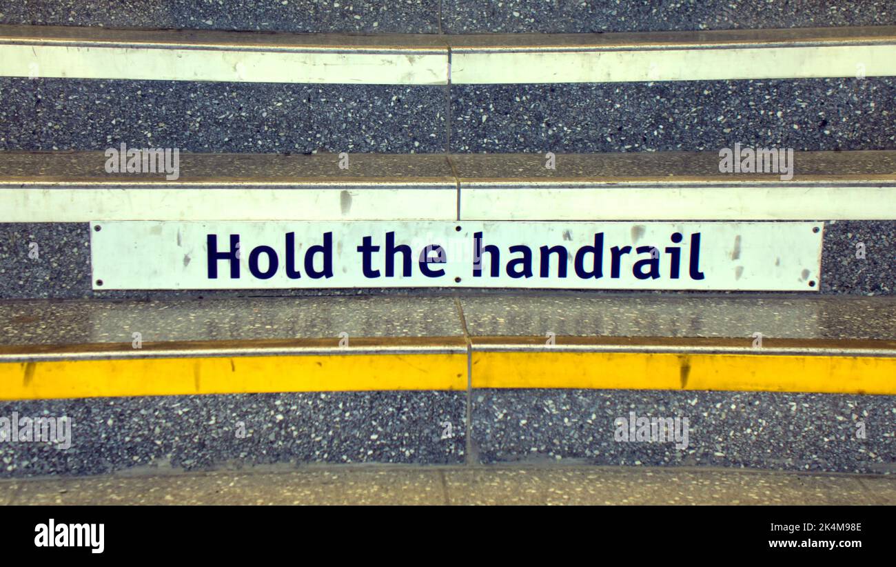 hold the handrail sign on step railway station Glasgow, Scotland, UK Stock Photo