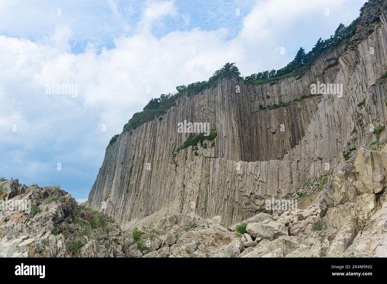 high coastal cliff formed by solidified lava stone columns, Cape Stolbchaty on Kunashir island Stock Photo