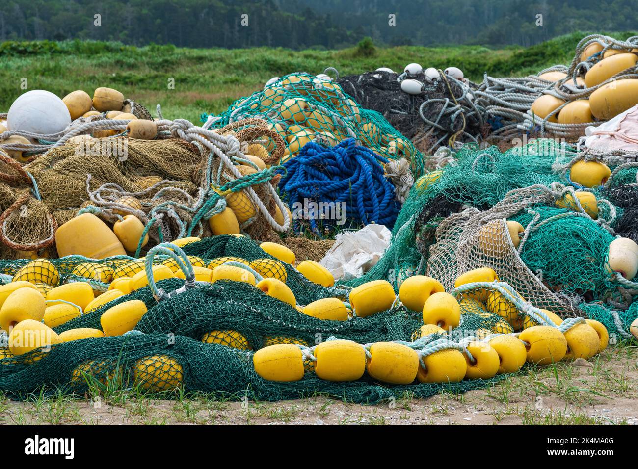 industrial fishing nets with bright floats is folded ashore Stock Photo