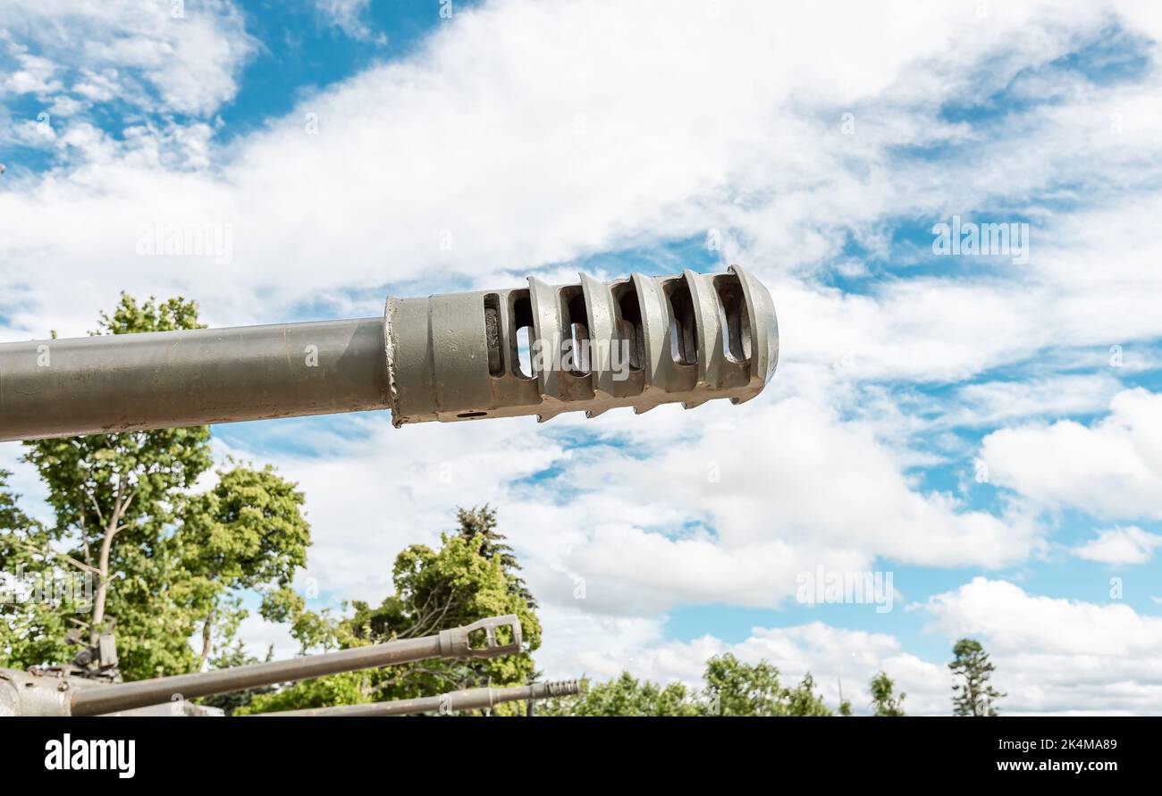 Tank muzzle over cloudy sky background and trees. War military concept photo Stock Photo