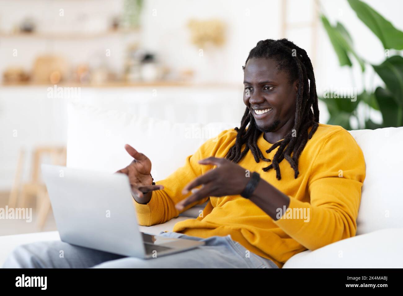 Distant Communication. Smiling Black Man Making Video Call On Laptop At Home Stock Photo