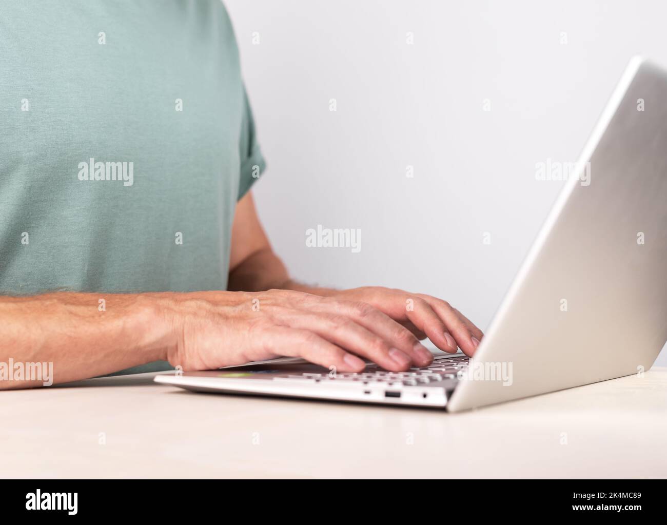 Hands closeup, typing, writing letter on laptop computer keyboard. Arms at PC on desk closeup. High quality photo Stock Photo