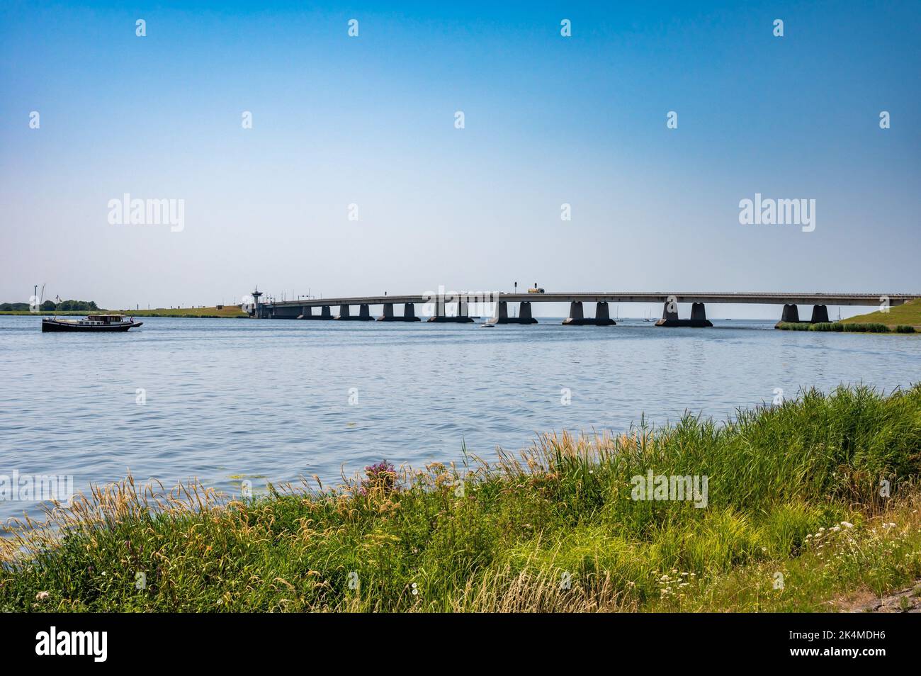 Nagele, Flevoland, The Netherlands - Bridge over the Ketel lake with the green polder and ships. Stock Photo