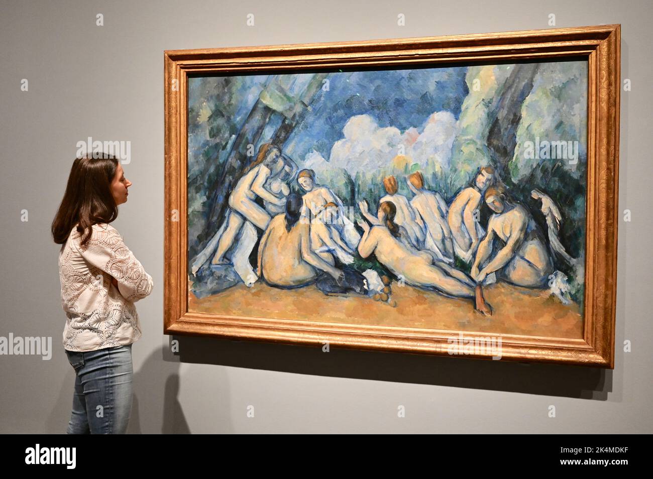 London, UK. A gallery employee views 'Bathers (Les Grandes Baigneuses)'1894-1905. Press Preview of The EY Exhibition: Cezanne. 5 October 2022- 12 March 2023. Tate Modern, Bankside. Stock Photo