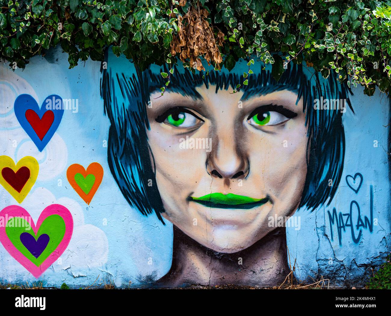 Girl's head graffiti by MazCan crowned by vegetation in Trafalgar lane ,North Laines area of Brighton, Stock Photo