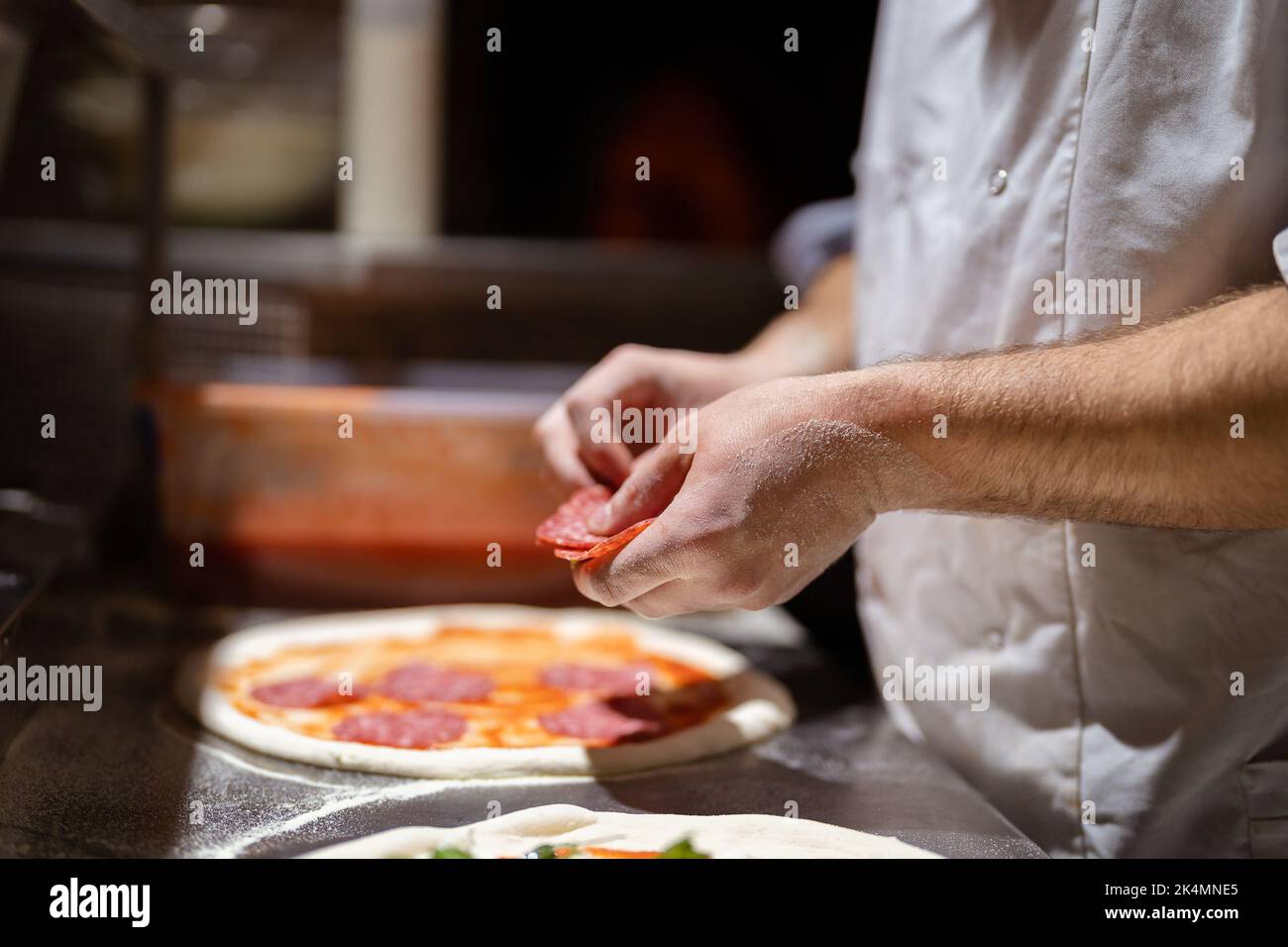 Pizza making process. Male chef hands making authentic pizza in the ...