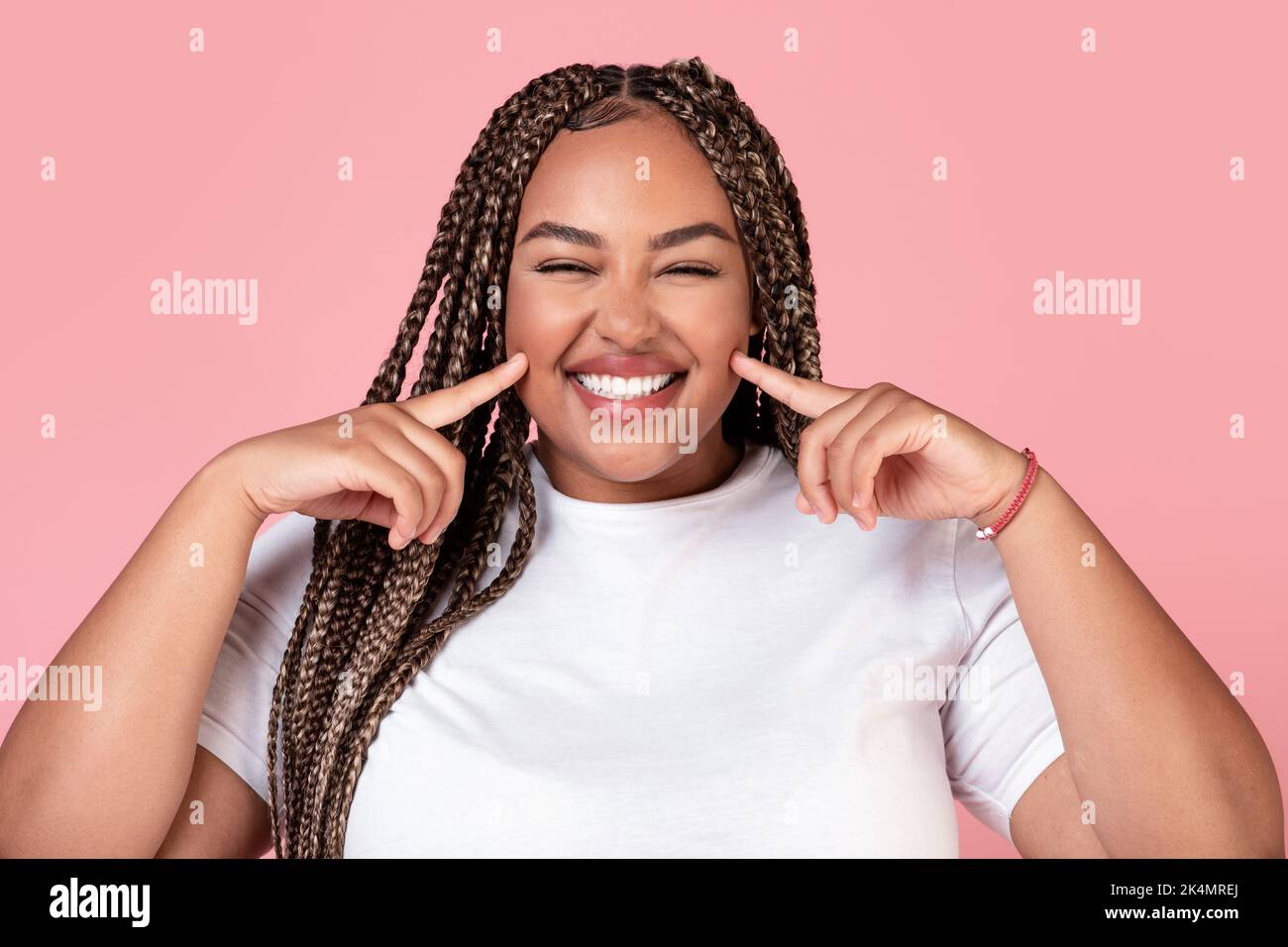 Happy African American Obese Lady Touching Cheeks Posing In Studio Stock Photo