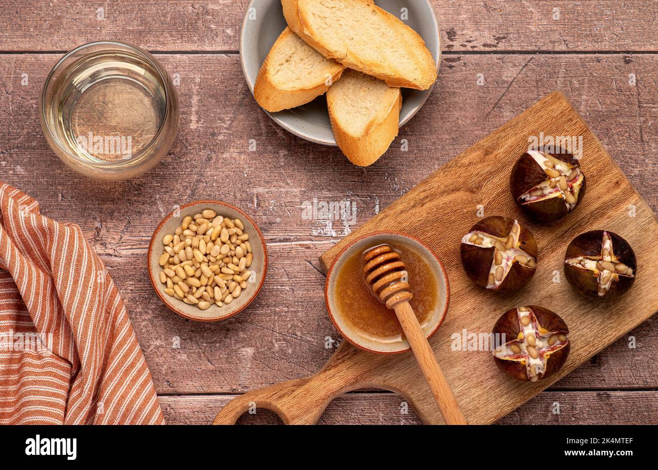Food photography of baked figs with goat cheese, pine nuts, honey Stock