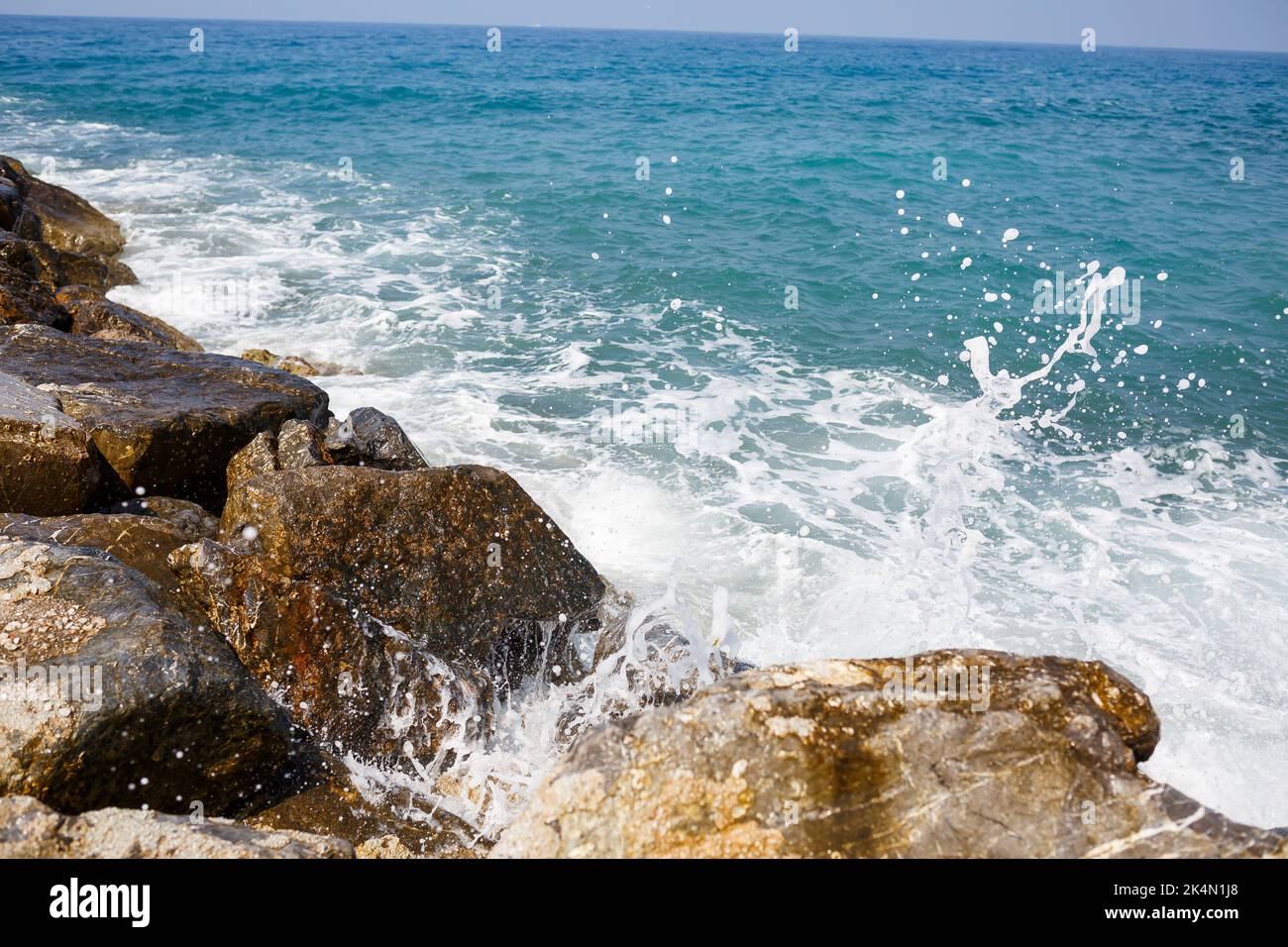 Sea water beats against rocky rocks and makes waves with foam Stock ...