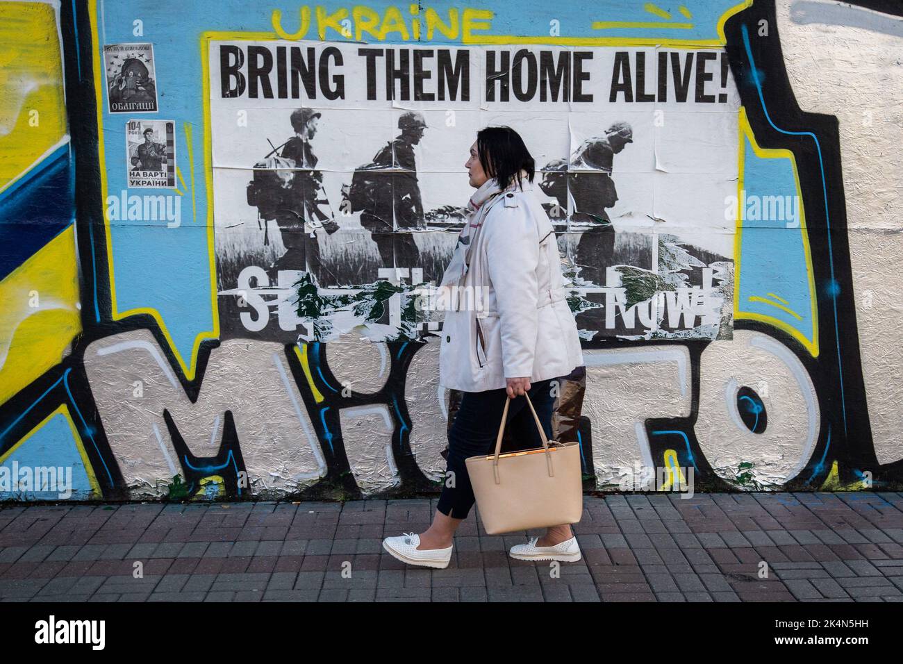 Kyiv, Ukraine. 24th Sep, 2022. A woman walks past the poster with the inscription 'Bring them home alive' in central Kyiv. Every day, an average of 50 Ukrainian soldiers die in battles with the Russian army. (Credit Image: © Oleksii Chumachenko/SOPA Images via ZUMA Press Wire) Stock Photo