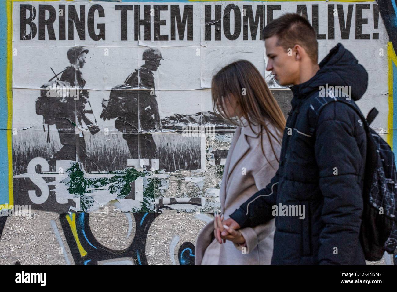 Kyiv, Ukraine. 24th Sep, 2022. People walk past a poster with the inscription 'Bring them home alive' in central Kyiv. Every day, an average of 50 Ukrainian soldiers die in battles with the Russian army. (Credit Image: © Oleksii Chumachenko/SOPA Images via ZUMA Press Wire) Stock Photo