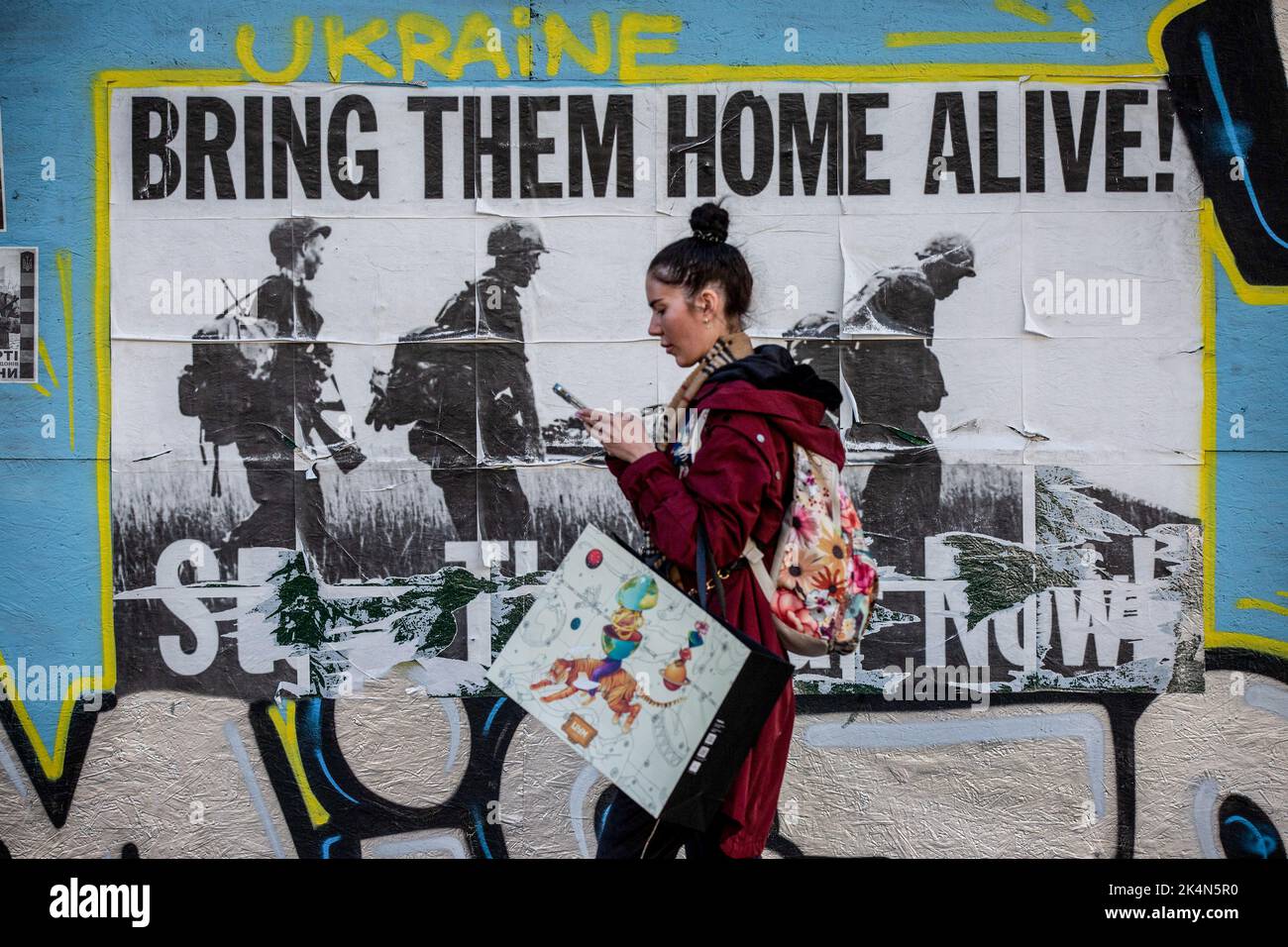 Kyiv, Ukraine. 24th Sep, 2022. A girl walks past the poster with the inscription 'Bring them home alive' in central Kyiv. Every day, an average of 50 Ukrainian soldiers die in battles with the Russian army. (Credit Image: © Oleksii Chumachenko/SOPA Images via ZUMA Press Wire) Stock Photo