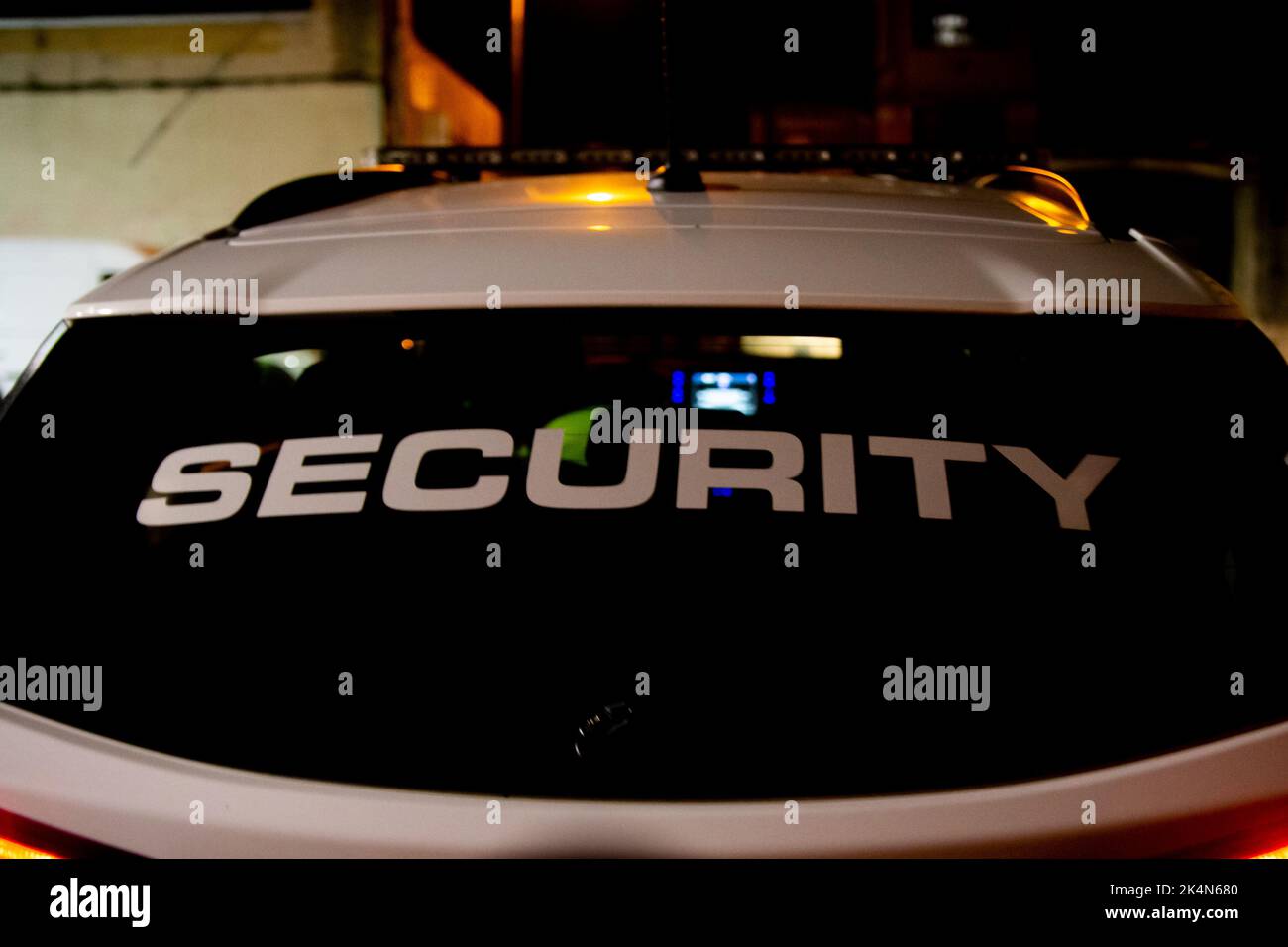 Security guard is driving a patrol car at night city Stock Photo